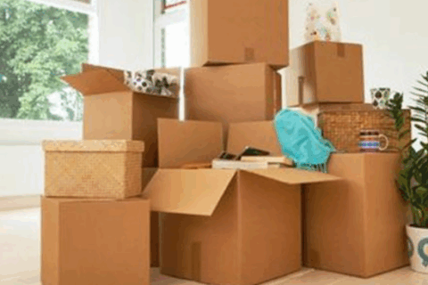 Stacked cardboard boxes in a sunlit room ready for moving